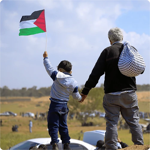Un vieil homme et un enfant portant le drapeau de la Palestine